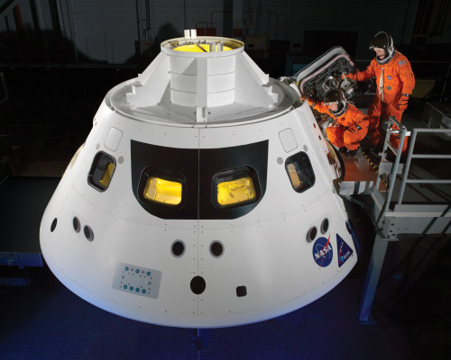 ALL ABOARD: NASA astronauts step into the Orion crew module hatch during a series of spacesuit tests conducted in 2013. The module will serve as both transport and a home for astronauts during future long-duration missions.