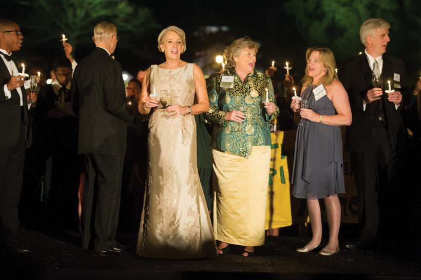 Sue Hanna Gerdelman '76, Cindy Satterwhite Jarboe '77 and Ellen Stofan '83 enjoy a candlelit rendition of the William & Mary Hymn, sung at the end of the campaign launch event.