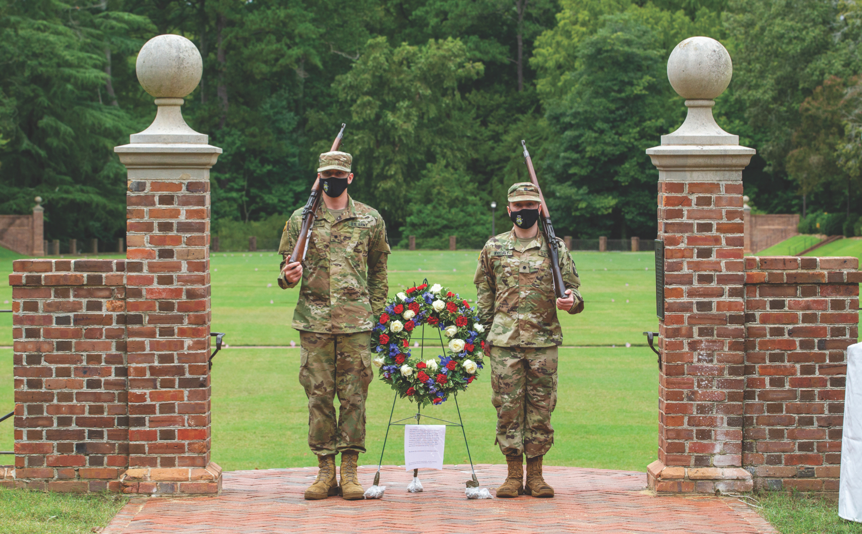 PAYING RESPECTS: Students stand guard with a wreath at the entrance of the Sunken Garden to honor the anniver- sary of 9/11.