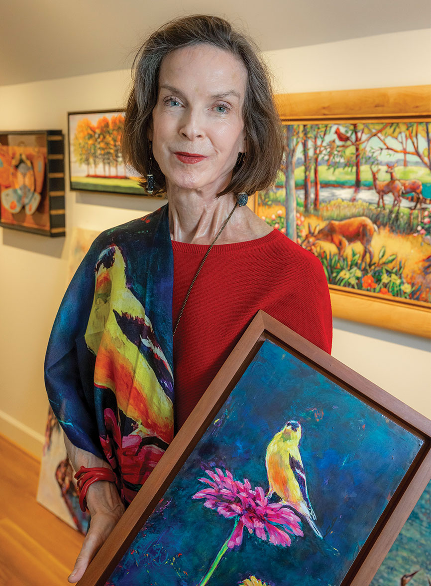 Connie Desaulniers holding one of her paintings