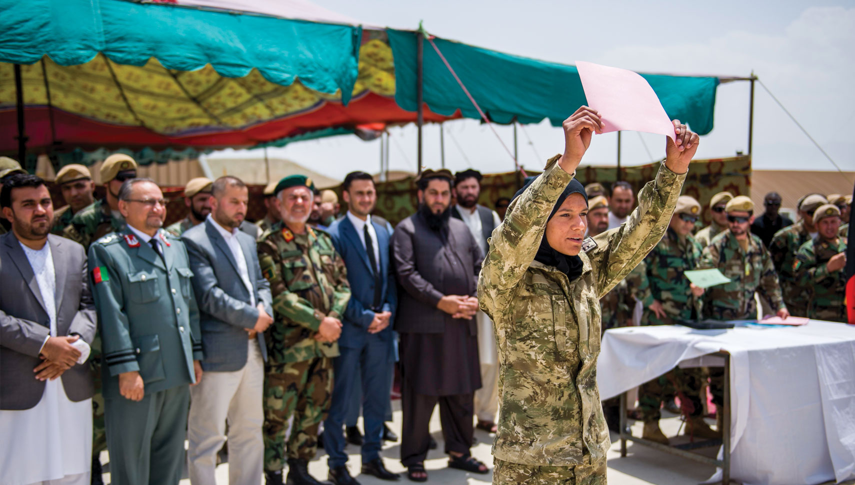 soldier holds up her basic training graduation certificate