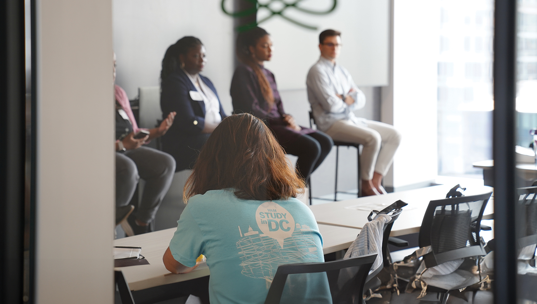 small panel of speakers in front of a class