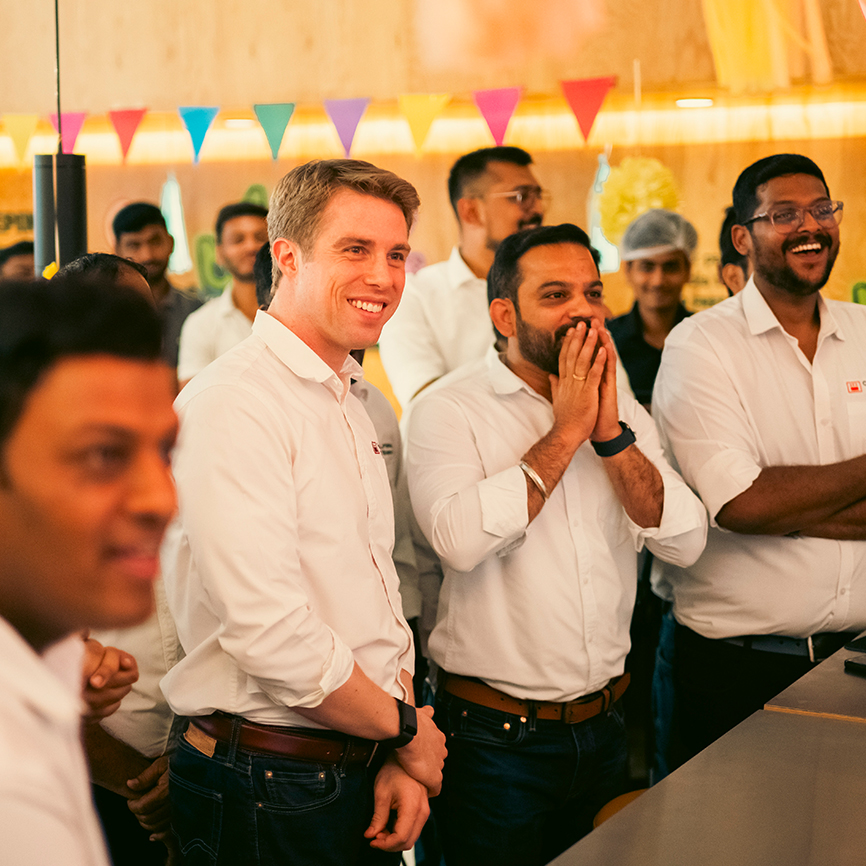 group of men smiling with in a room decorated for a party