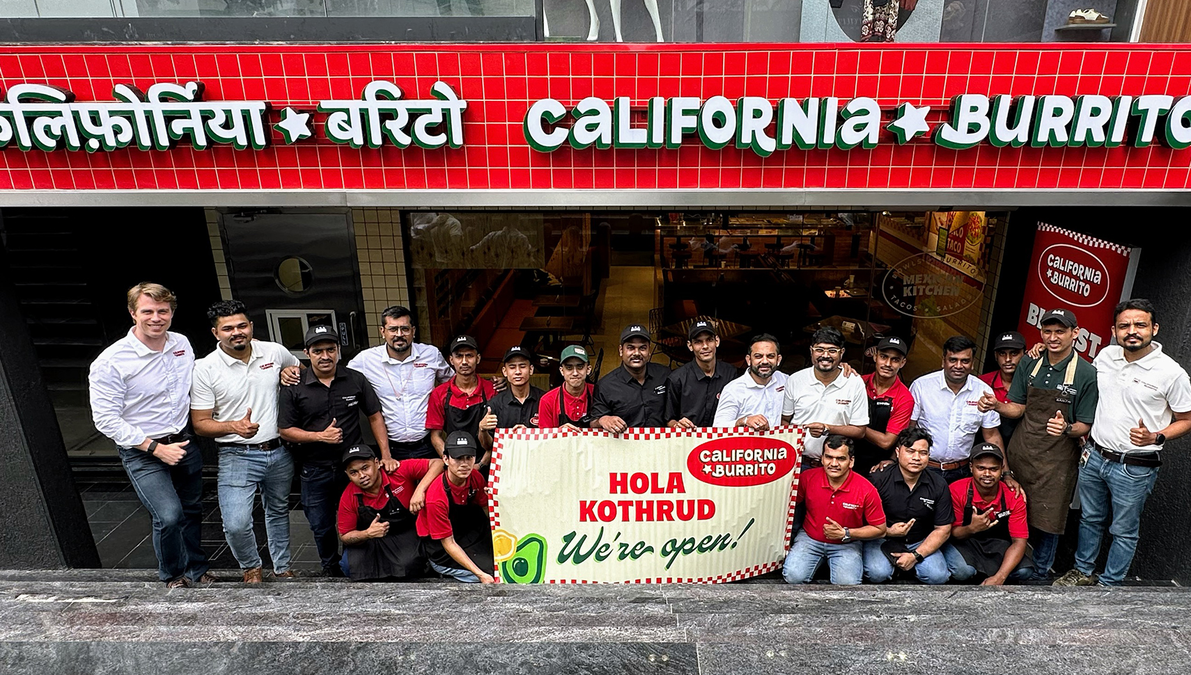 group in front of restaurant with sign in multiple languages