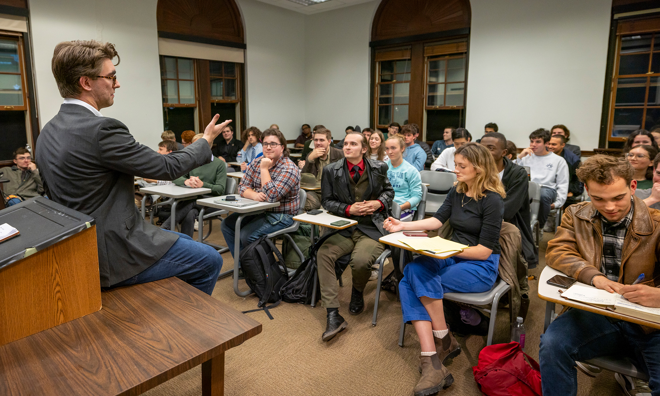A speaker address a classroom full of students seated at desks
