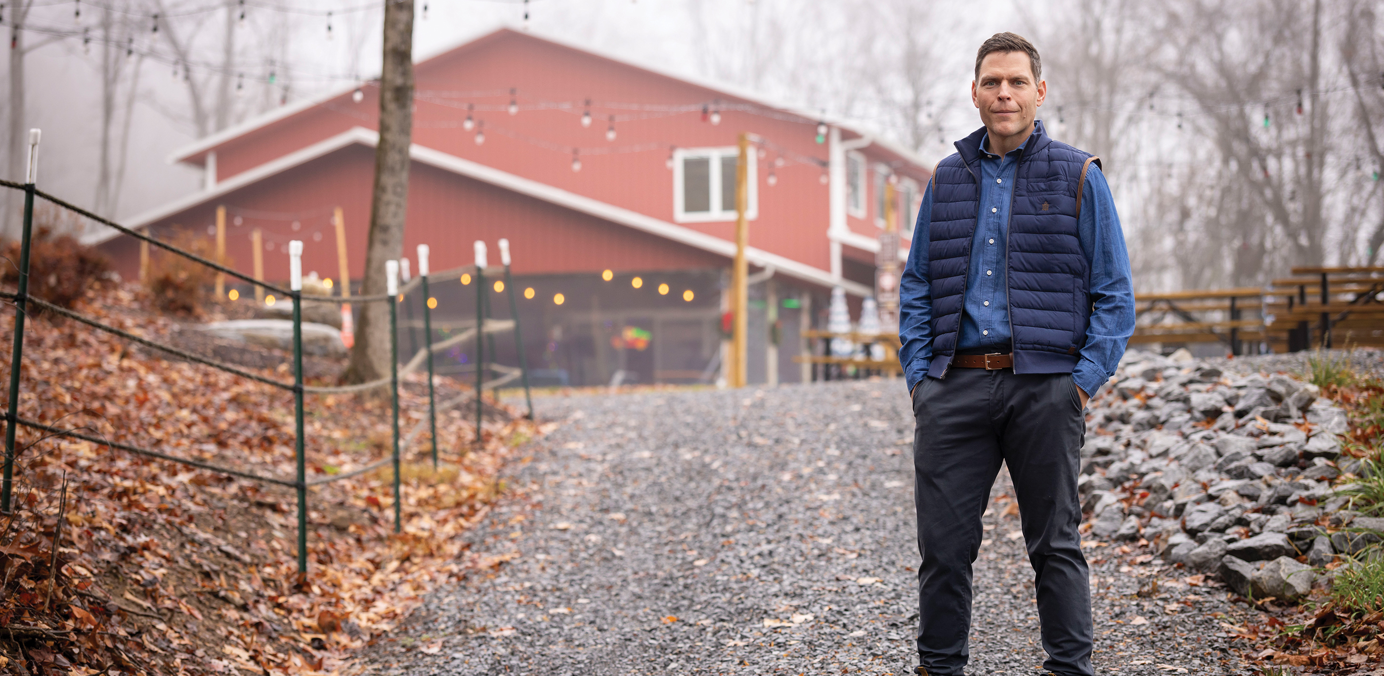 Will Payne standing in front of a red barn style building with bistro lights