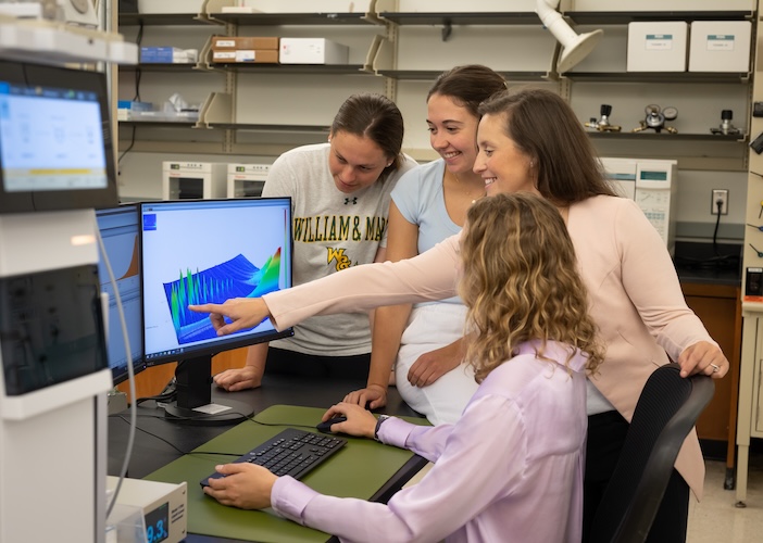 Perrault Uptmor and her students gather around a computer.