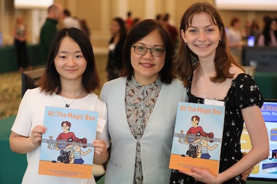 Rachel Chung with two students holding a book