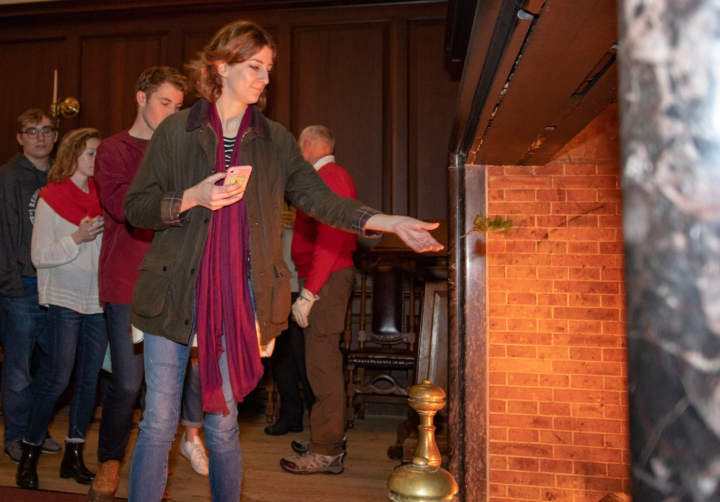 Members of the W&M community throw holly into the Yule Log fire